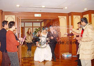 Friends spray colorful flowers to the newly-wed.